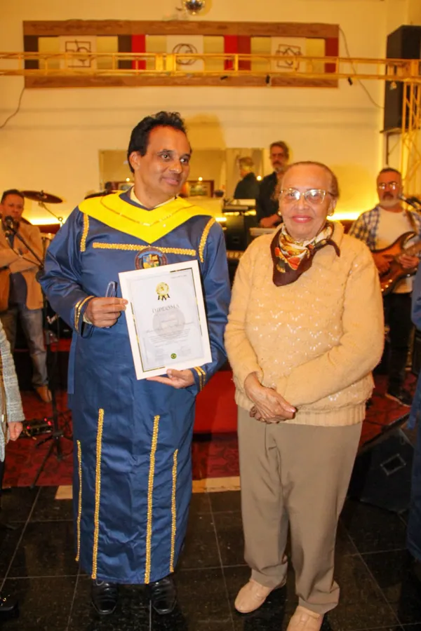 Registro fotográfico de entrega de diploma durante evento da Academia